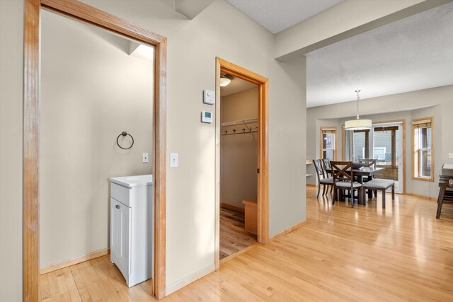 hallway with baseboards and light wood-style flooring