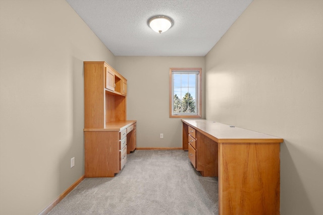 office featuring baseboards, light colored carpet, and a textured ceiling