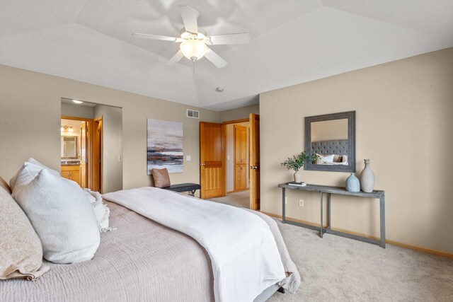 bedroom featuring visible vents, light carpet, lofted ceiling, connected bathroom, and baseboards