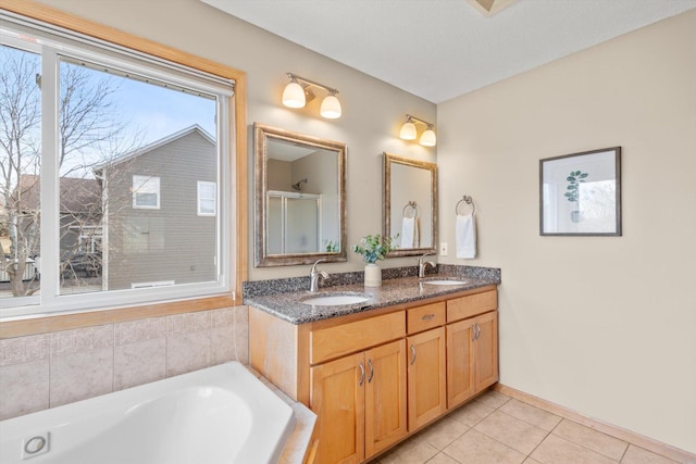 full bath featuring a sink, double vanity, a tub, and tile patterned floors