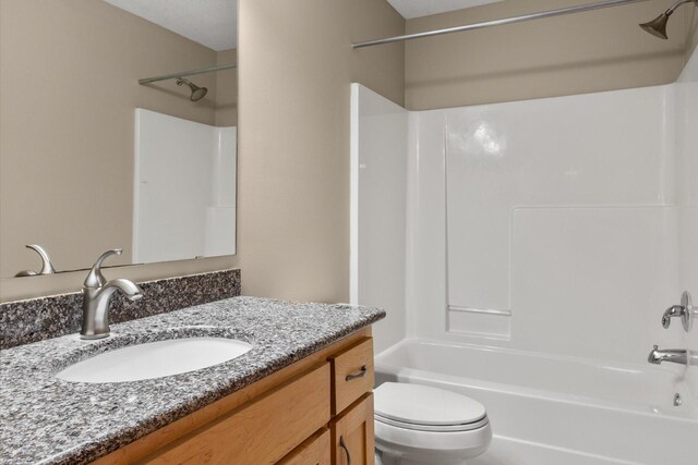 bathroom featuring vanity, toilet, and shower / bathtub combination