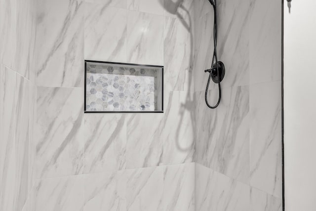 room details featuring a marble finish shower