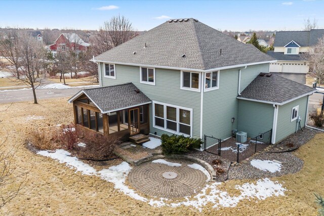 rear view of property with fence, roof with shingles, cooling unit, a sunroom, and a gate