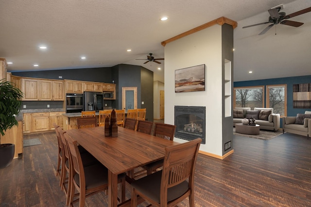 dining room with a textured ceiling, lofted ceiling, recessed lighting, dark wood-style floors, and a glass covered fireplace