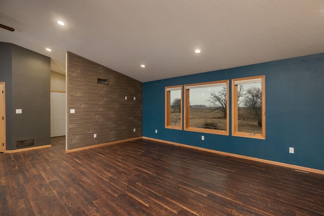 unfurnished room featuring wooden walls, baseboards, lofted ceiling, wood finished floors, and recessed lighting