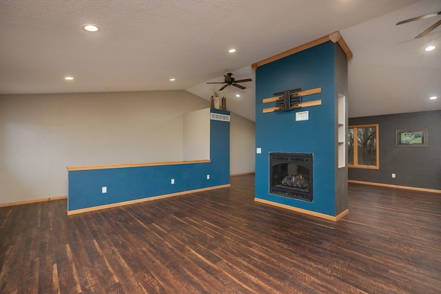 unfurnished living room with lofted ceiling, ceiling fan, wood finished floors, and a glass covered fireplace