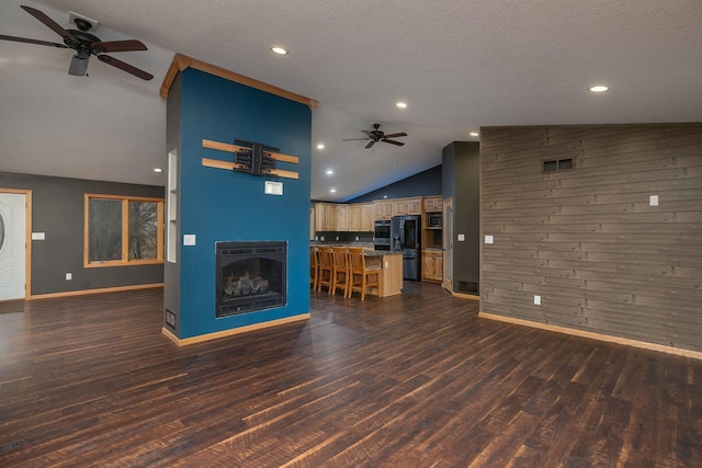 unfurnished living room with dark wood-style floors, ceiling fan, a fireplace, and a textured ceiling