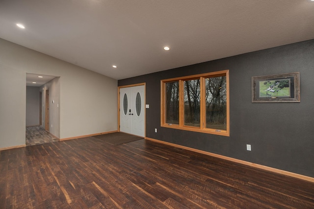 unfurnished room with lofted ceiling, recessed lighting, wood finished floors, and baseboards