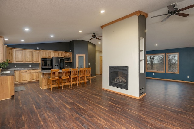 kitchen featuring light brown cabinets, stainless steel microwave, open floor plan, and black fridge with ice dispenser