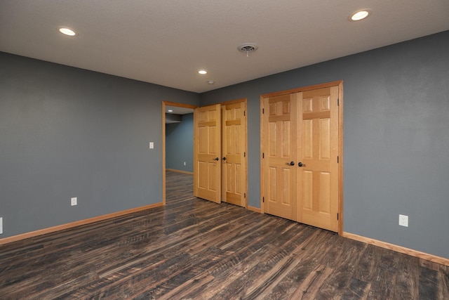 unfurnished bedroom featuring dark wood-type flooring, recessed lighting, and baseboards