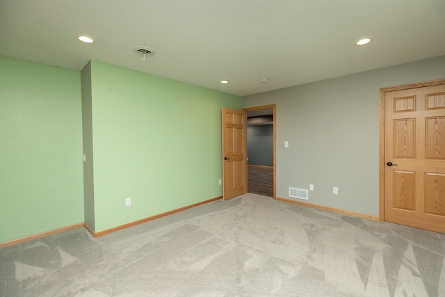 unfurnished bedroom featuring light carpet, visible vents, and baseboards