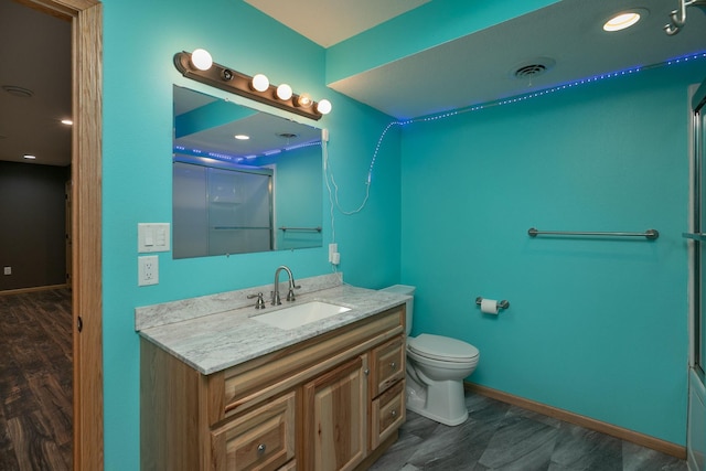 full bathroom with baseboards, visible vents, toilet, wood finished floors, and vanity