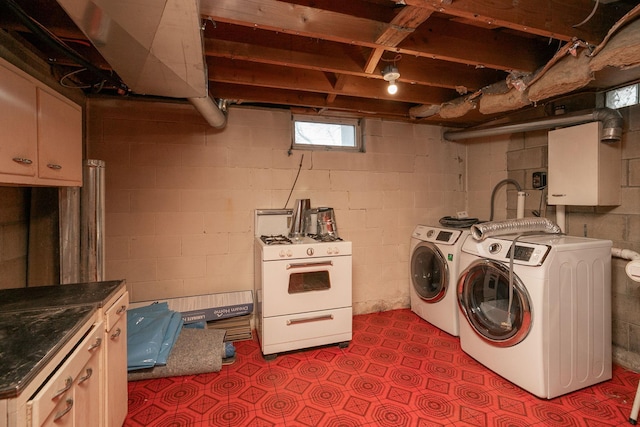 clothes washing area with dark floors, cabinet space, and washer and clothes dryer