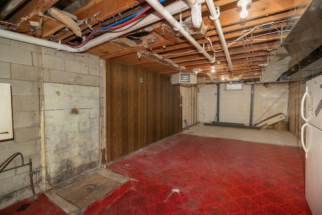 unfinished basement featuring freestanding refrigerator