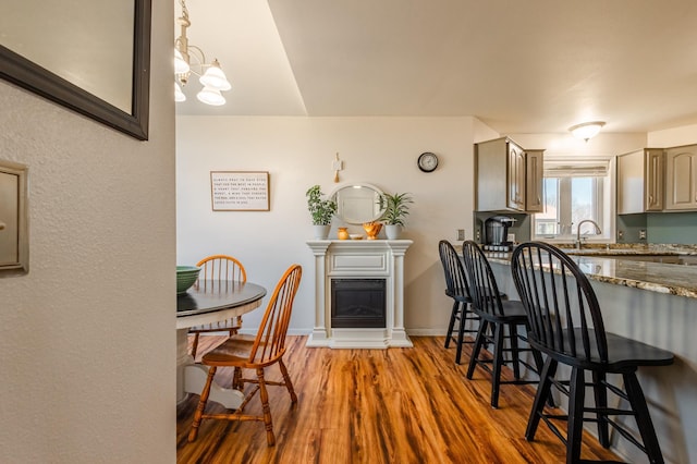 dining room with baseboards, wood finished floors, and a glass covered fireplace