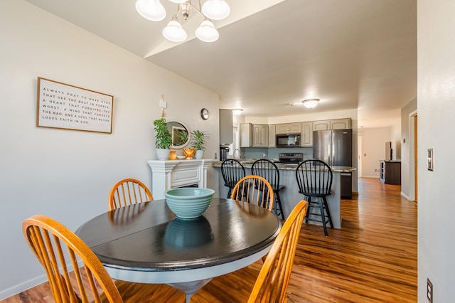 dining room featuring a notable chandelier, baseboards, and wood finished floors