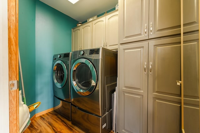 laundry area featuring cabinet space, baseboards, dark wood-style floors, and washing machine and clothes dryer