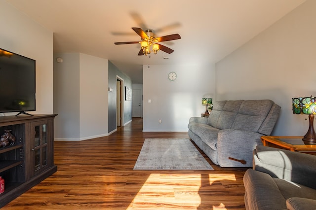 living area with dark wood-style floors, baseboards, and a ceiling fan