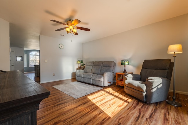 living area featuring ceiling fan, baseboards, and wood finished floors