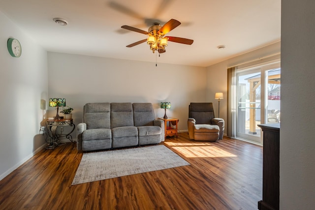 living area with a ceiling fan, visible vents, baseboards, and wood finished floors