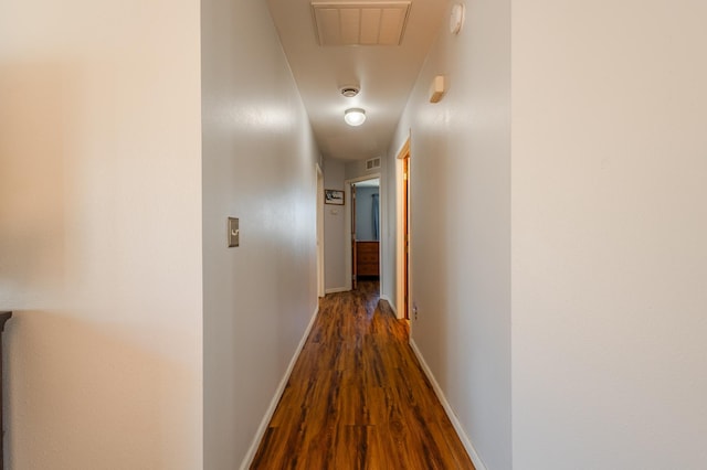 corridor featuring baseboards, visible vents, and dark wood-style flooring