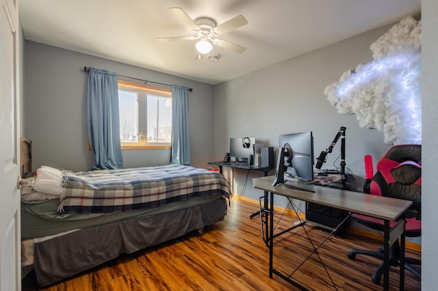 bedroom with wood finished floors, a ceiling fan, and baseboards