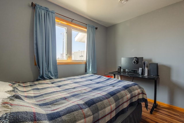 bedroom with baseboards and wood finished floors