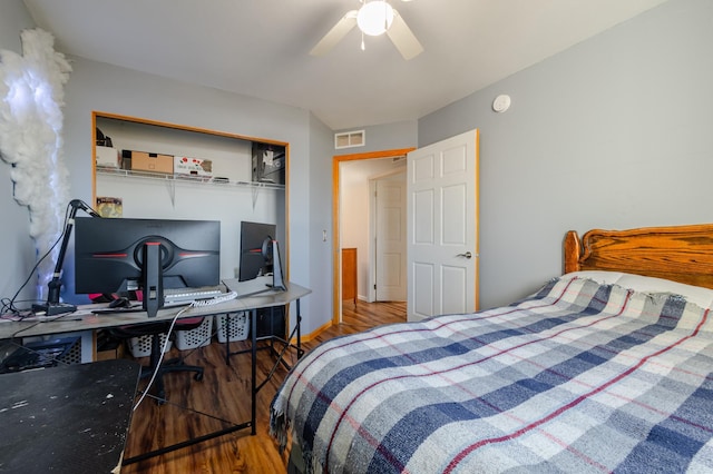 bedroom with wood finished floors, visible vents, and a ceiling fan