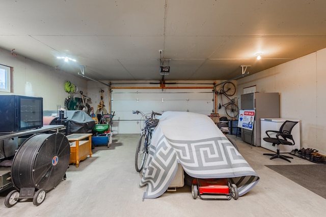 garage with a garage door opener and freestanding refrigerator