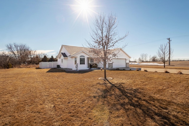 ranch-style home with a front lawn, an attached garage, and fence