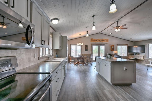 kitchen with wood finished floors, appliances with stainless steel finishes, a sink, and gray cabinetry