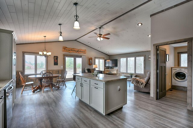 kitchen featuring washer / dryer, dishwasher, lofted ceiling, dark wood-style floors, and open floor plan