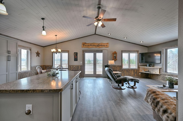 kitchen featuring lofted ceiling, a wainscoted wall, wood ceiling, dark countertops, and ornamental molding