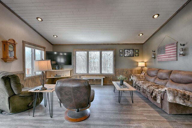 living area with ornamental molding, wainscoting, wood finished floors, and wooden walls