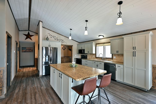 kitchen with lofted ceiling, a kitchen island, dark wood-style flooring, black appliances, and a sink