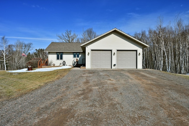 ranch-style home featuring a garage, driveway, and a shingled roof