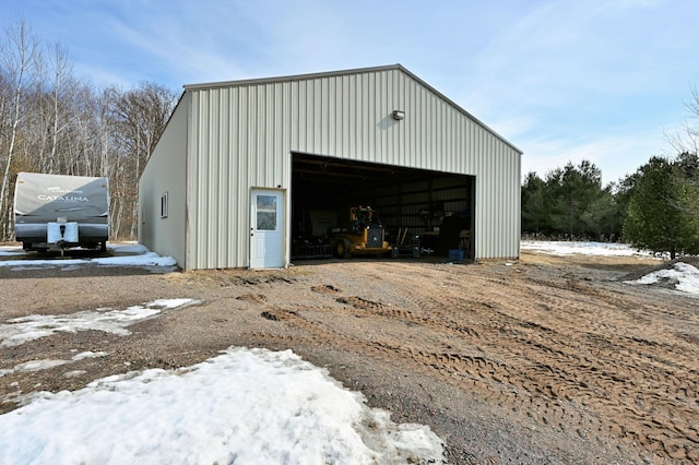 snow covered garage with a detached garage