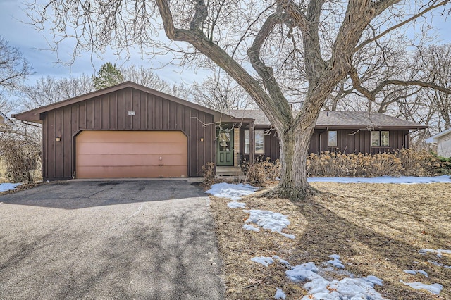 view of front of house with driveway, a shingled roof, a garage, and board and batten siding