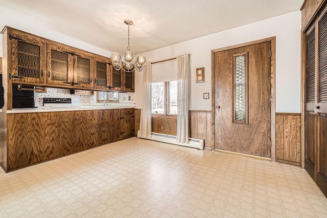 kitchen with tile patterned floors, wood walls, and wainscoting