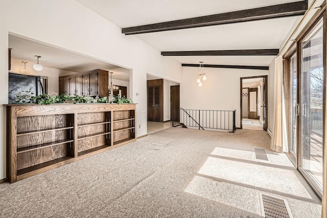 carpeted empty room featuring visible vents and beamed ceiling