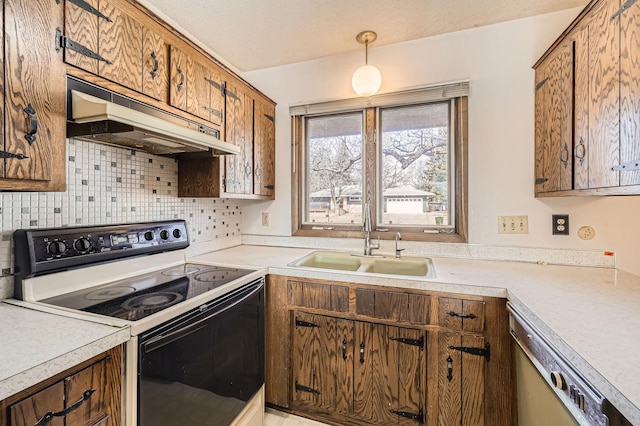 kitchen with electric stove, under cabinet range hood, a sink, brown cabinetry, and dishwasher