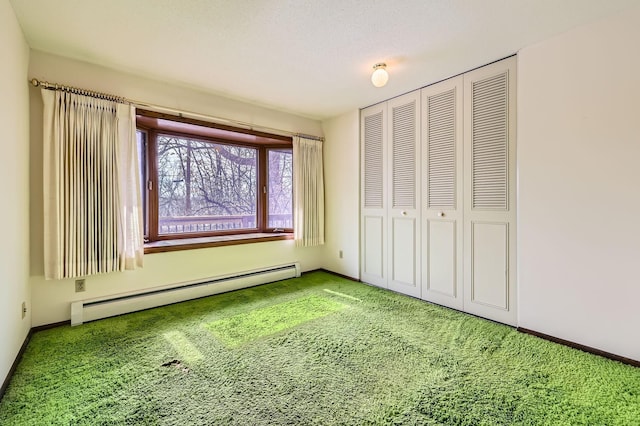 unfurnished bedroom featuring a baseboard heating unit, baseboards, a closet, and carpet flooring