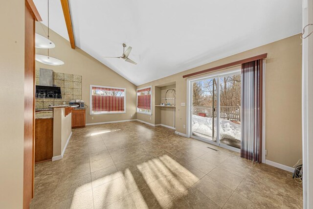 unfurnished living room featuring a ceiling fan, tile patterned flooring, high vaulted ceiling, and baseboards