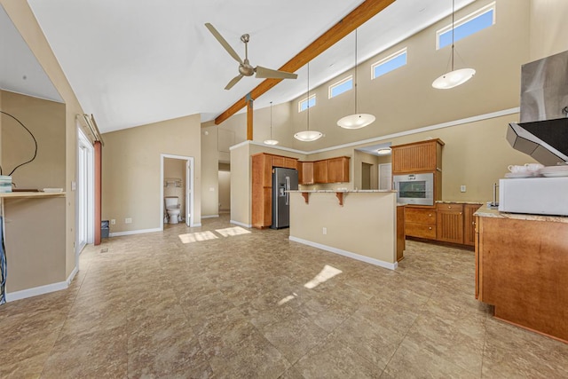 kitchen with a breakfast bar, appliances with stainless steel finishes, brown cabinetry, open floor plan, and ceiling fan