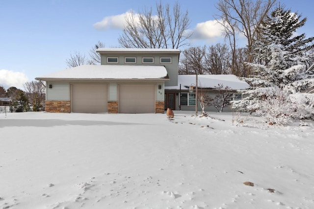 view of front of home with a garage and stone siding