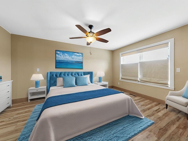 bedroom featuring a ceiling fan, light wood-type flooring, and baseboards