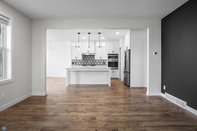 kitchen with visible vents, white cabinets, decorative backsplash, dark wood finished floors, and appliances with stainless steel finishes