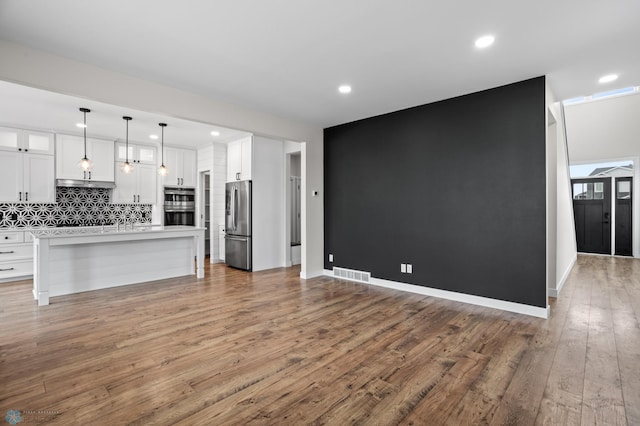 kitchen featuring appliances with stainless steel finishes, visible vents, light wood finished floors, and white cabinetry