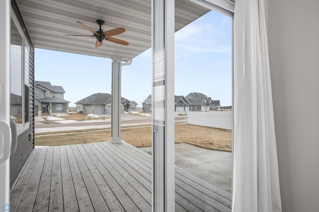 wooden terrace featuring a residential view and ceiling fan