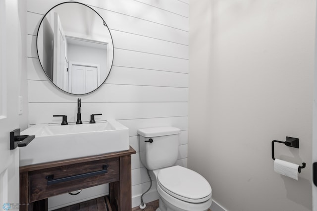 bathroom featuring toilet, vanity, and baseboards